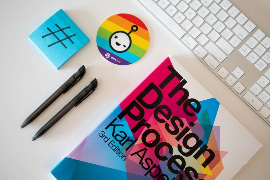 Un laptop poggiato su un letto mostra un software di web design, dando vita a un angolo di lavoro accogliente.
