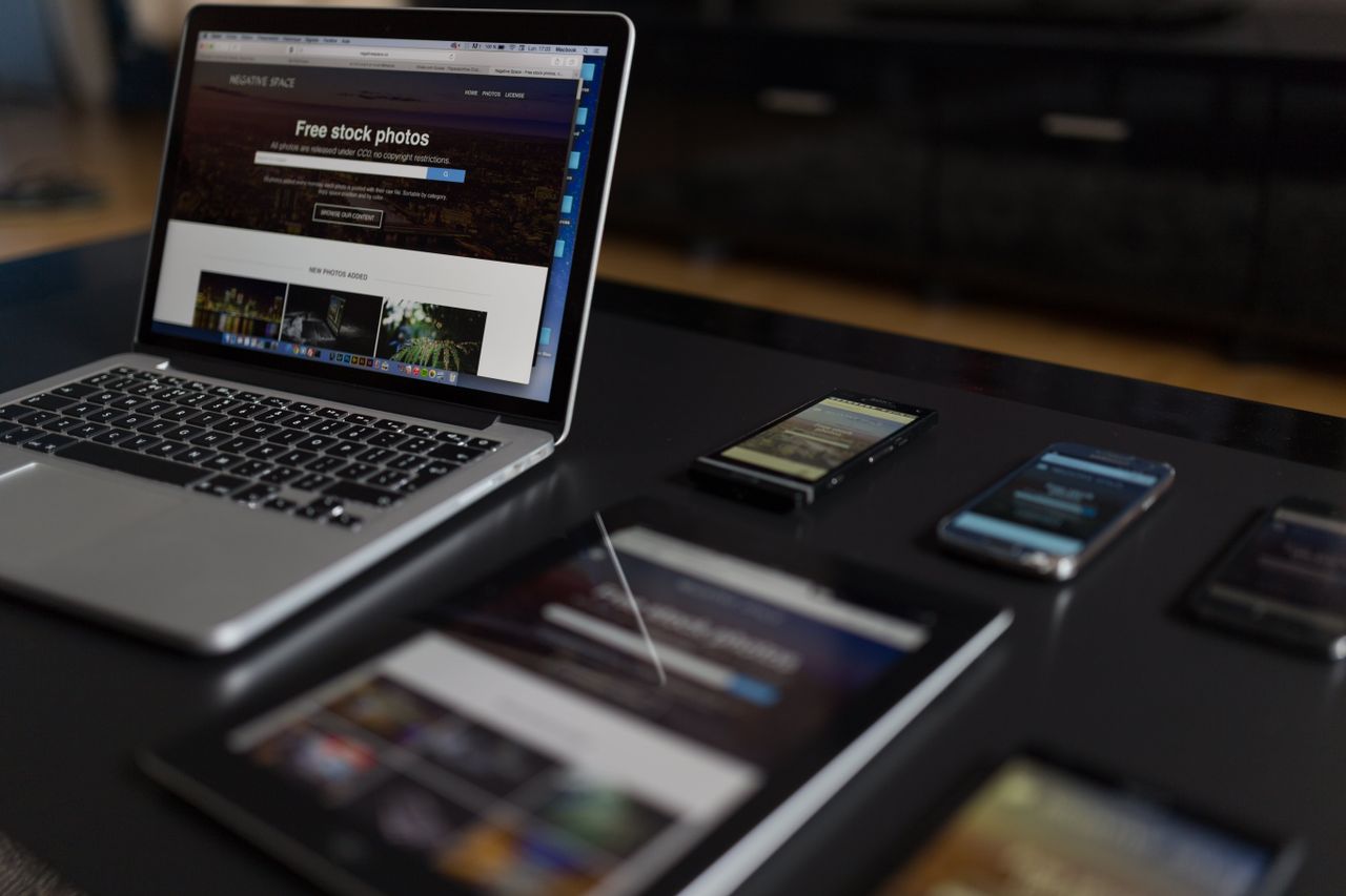 Uno spazio di lavoro contemporaneo con laptop, tablet e smartphone, ideale per l’uso tecnologico e freelance.